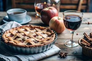 Appetizing and fragrant apple pie on a tablecloth, next to fresh apples, spices and a cup of tea and a glass of mulled wine, autumn, breakfast, dessert, seasonal dishes photo
