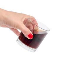 Female hand holding glass with drink on isolated background photo