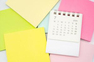 Simple desk calendar for JULY 2025 with Sticky note. Calendar concept with copy space. 2025 JUL calendar. photo
