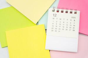 Simple desk calendar for DECEMBER 2025 with Sticky note. Calendar concept with copy space. 2025 DEC calendar. photo