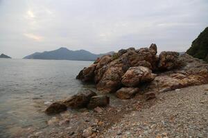 A rocky beach with a body of water in the background photo