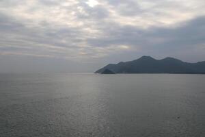 The sea surface is calm, with distant islands and mountains in the distance photo