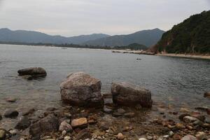 A rocky shoreline with a body of water in the background photo