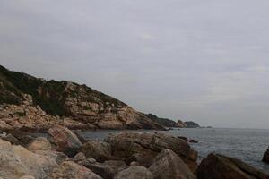 A rocky shoreline with a cloudy sky in the background photo
