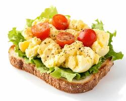 Crushed egg salad with cherry tomatoes on whole-grain bread, isolated on a white background photo