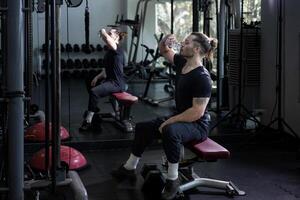 Caucasian man enjoy morning exercise in the gym while having a break to drink mineral water for refreshment and rehydration concept photo