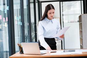 Professional reviewing documents and analyzing data in a modern office photo