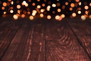 Empty rustic wooden table with blurred Christmas lights at background. photo