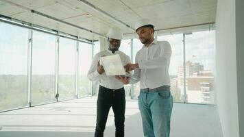 Multiethnic manual worker and engineer discussing on plan video