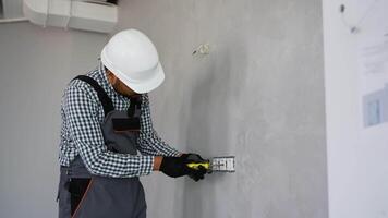 Indian electrician installing an electrical socket in a office video