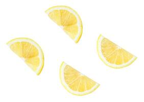 Fresh yellow lemon fruit in four slices or quarters scattering in set isolated on white background with clipping path Top view photo