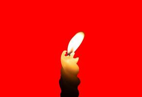 AA yellow spiral candlestick with candlelight isolated on red background with clipping path photo