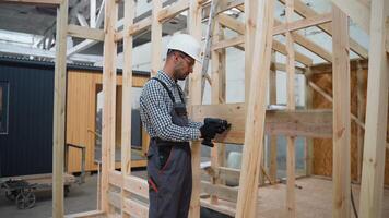 Handsome man builder working at prefabricated house building construction site video