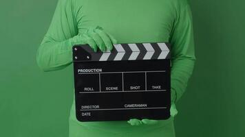 Movie Clapper board clapped by Hands on green screen camera background. Filmmaker hit film slate on green camera frame. Clapperboard Chroma key suit shooting. Green screen composite film production. video