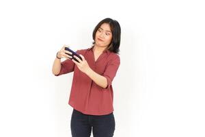 Playing Mobile Game on Smartphone Of Beautiful Asian Woman Isolated On White Background photo