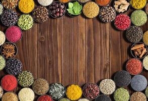 Indian Spices and herbs with space for label. Various condiments on wooden table, top view. Colorful seasoning for food photo