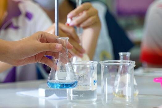 Close-up of a student performing an acid-base titration experiment. Concept of chemistry lab, science, experiment, skills, learning. photo