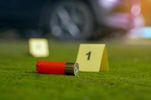 Bullet casings fell on the moss growing on the cement floor and blurry background of the evidence number plate at the scene and the car belonging to the culprit. Concept of investigation photo