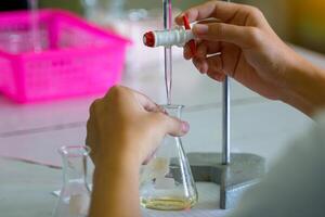 Close-up of a student performing an acid-base titration experiment. Concept of chemistry lab, science, experiment, skills, learning. photo