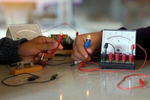 students are conducting experiments on basic electrical circuits. Concept of science classroom, learning science, science skills, learning, science experiments. photo