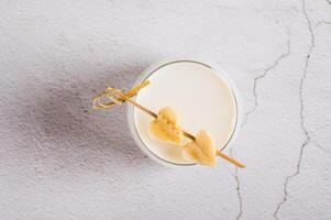 Close up of alternative lactose free banana milk in a glass on the table top view photo