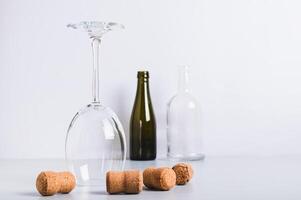 Alcohol abstinence, upside down wine glass among corks on table photo