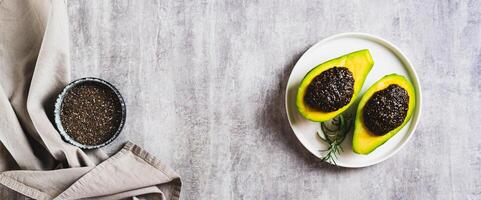 Vegetarian avocado with black chia caviar on a plate on the table top view web banner photo