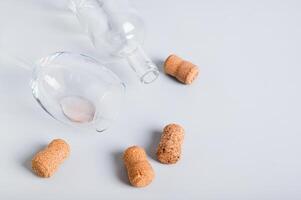 Refusal of alcohol, empty glass, bottle and corks on gray background photo