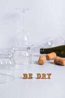 Dry January concept, empty glasses, bottles and corks on a gray background vertical view photo