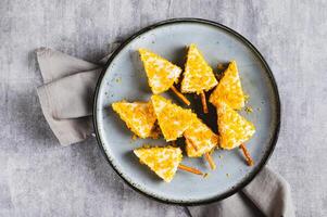 Close up of Christmas trees made from triangle cheese in nacho crumbles on a plate top view photo