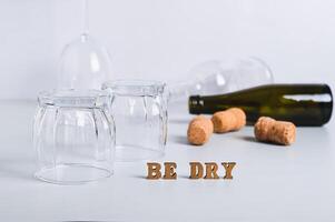 Dry January concept, empty glasses, bottles and corks on a gray background photo