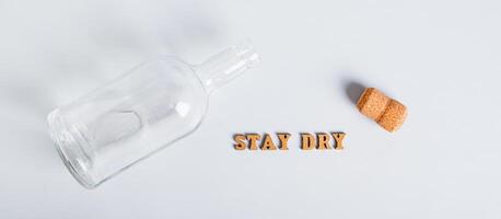 Dry January concept, empty bottle, corks and text on grey background web banner photo