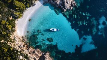 A boat is floating in a blue ocean with a rocky shoreline photo
