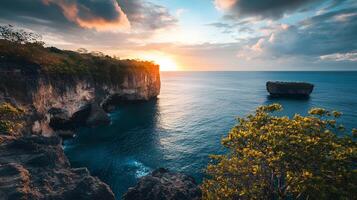A beautiful sunset over the ocean with a rocky cliff in the background photo