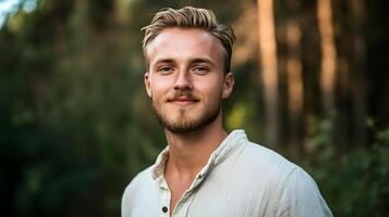 A man with a beard and a smile is standing in a forest photo