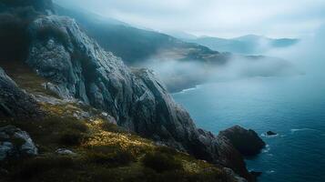 A mountain range with a foggy sky and a body of water in the background photo