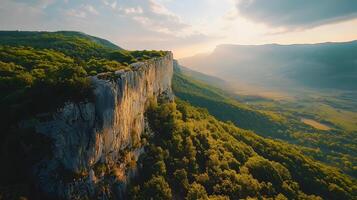 A mountain range with a rocky cliff and a lush green forest photo