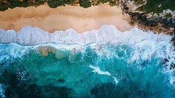 The ocean is calm and blue, with a few white waves breaking on the shore photo
