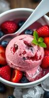Delicious bowl of strawberry and berry ice cream topped with fresh fruits and mint photo