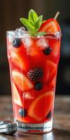 Refreshing summer cocktail with mixed fruits and ice in a clear glass photo