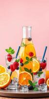 Refreshing fruit punch with strawberries, oranges, and mint displayed on a vibrant pink background photo