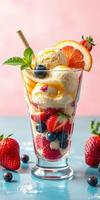 Fresh fruit and ice cream sundae served in a glass with mint leaves garnished on a colorful background photo