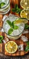 Refreshing mint lemon drink with ice served in a glass on a wooden surface with lime slices photo