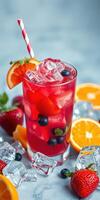 Refreshing summer drink with mixed fruits and ice cubes served on a light blue background photo