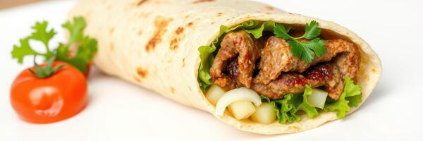 Savory wrap filled with grilled meat, fresh vegetables, and herbs served on a white plate photo