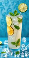 Refreshing lemon and mint drink served in a tall glass with ice on a colorful background photo
