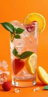 Refreshing summer cocktail with strawberries, lemon, and mint on a vibrant orange background photo