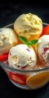 Delicious creamy ice cream served with fresh fruits in a clear bowl on a dark background photo