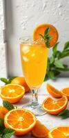 refrescante agrios bebida servido con Fresco naranja rebanadas y menta hojas en un blanco mesa foto