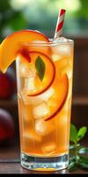 Delicious peach iced tea garnished with fresh mint leaves served in a tall glass on a warm summer afternoon photo